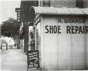 Abe Barash, standing in the entrance to his repair shop, Madison, ca 1940